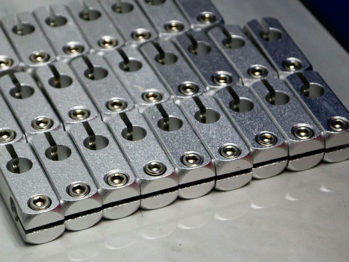 Rows of identical machined metal components held in a production fixture
