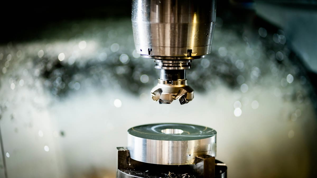 CNC spindle and cutter machining a circular component held in a fixture