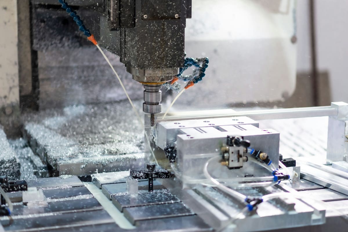 Machine tool cutting a metal workpiece with coolant flowing across the surface