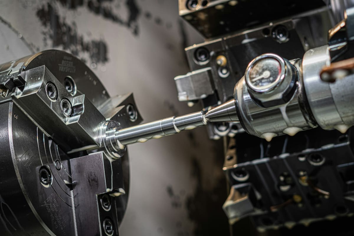 Close view of a lathe chuck holding tooling against a machined workpiece