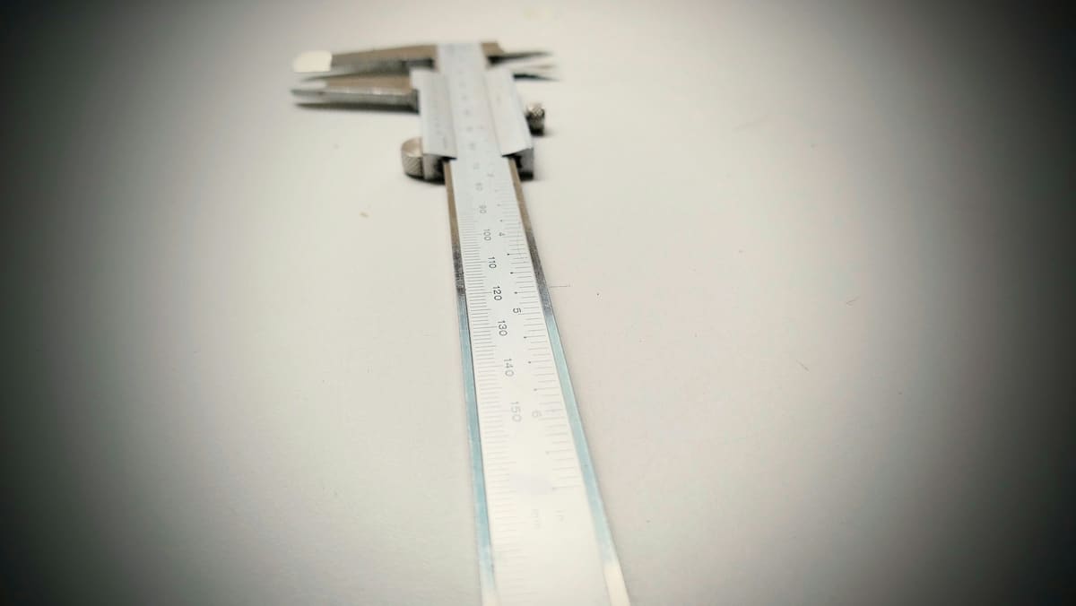 Precision measuring rule and caliper laid out on a clean planning surface
